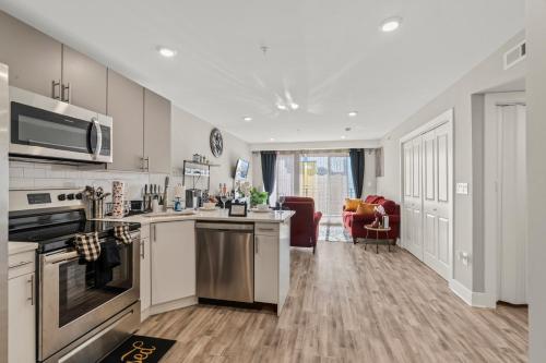 a kitchen with a stove top oven next to a living room at 2BR-2BA Luxy Dendrobium Oasis, Pet Friendly, Family Friendly, Free Parking & Balcony in Philadelphia