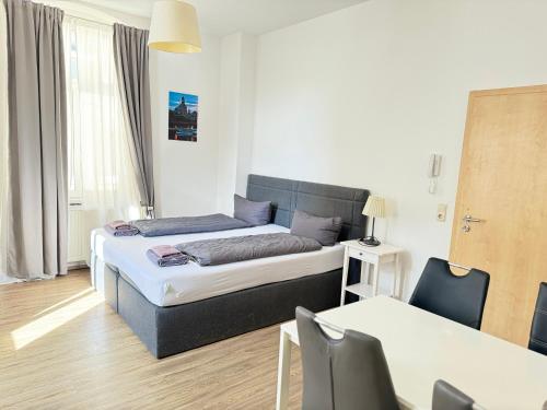 德勒斯登的住宿－德累斯頓山公寓，卧室配有一张床和一张桌子及椅子