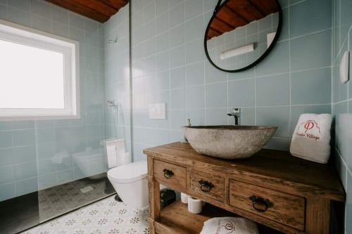 a bathroom with a sink and a toilet and a mirror at Penedo Village in Marco de Canaveses