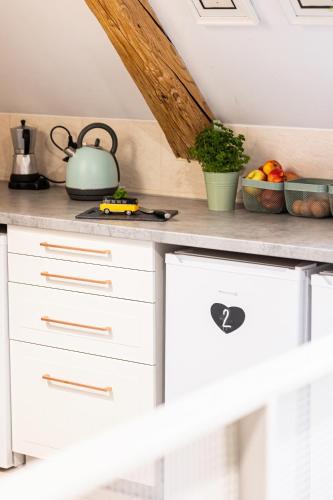 a kitchen with white cabinets and a tea kettle at Nasze Calle in Węgorzewo