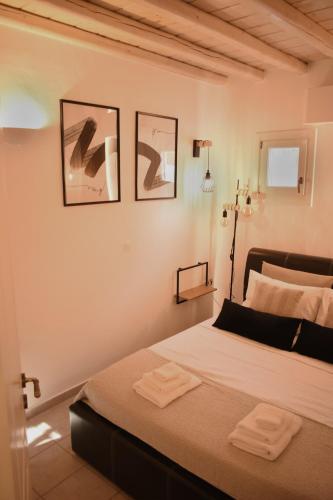 a bedroom with a bed with two towels on it at NISOS Home Stay in Mýkonos City