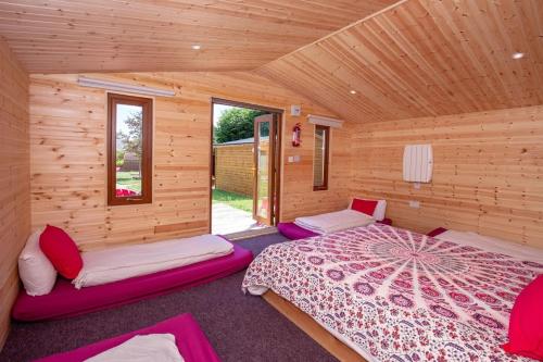 sypialnia z 2 łóżkami w drewnianym domku w obiekcie Podumna Glamping Village w mieście Portumna