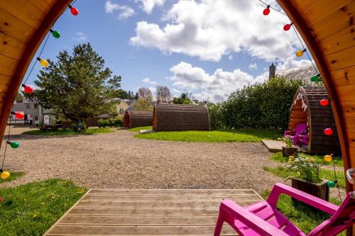 a gazebo with two pink chairs in a yard at Podumna Glamping Village in Portumna