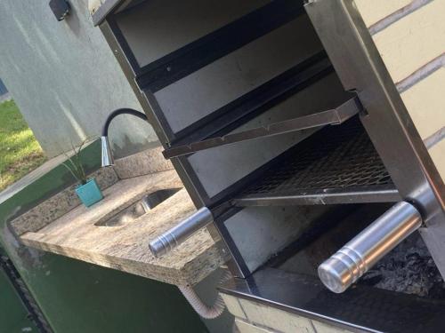 a barbecue grill on the side of a house at CASA PRAIA DO FORTE in Mata de Sao Joao