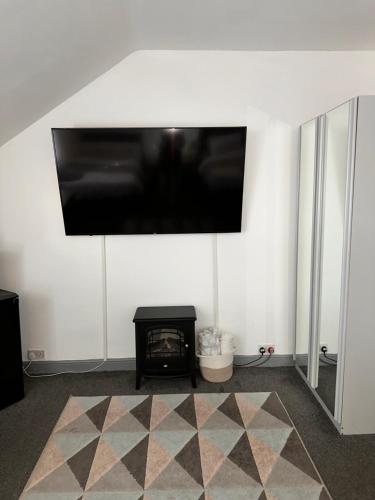 a living room with a flat screen tv on a wall at P&S rooms guesthouse Lincoln city centre in Lincolnshire