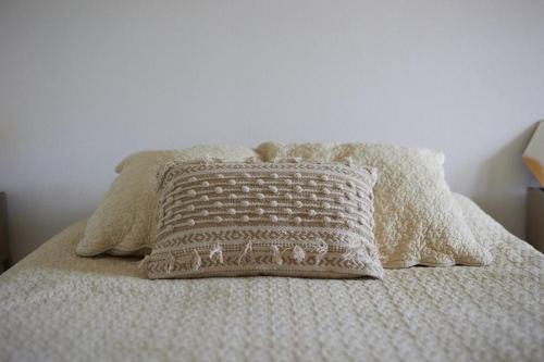 - un lit blanc avec un oreiller dans l'établissement À Laye station Charmant T1 33 m2, à Laye