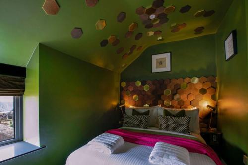 a bedroom with a large bed with a green wall at The Hive, Central Ludlow, Free Parking, Boutique Hotel Style in Ludlow
