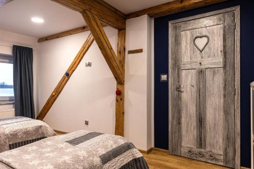 a bedroom with two beds and a wooden door at Nasze Calle in Węgorzewo