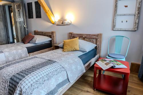 two beds in a room with a table and a chair at Nasze Calle in Węgorzewo