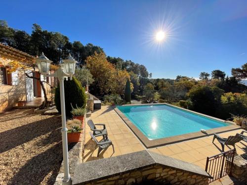 uma piscina com duas cadeiras e uma casa em Ô Coeur Des Ocres em Roussillon