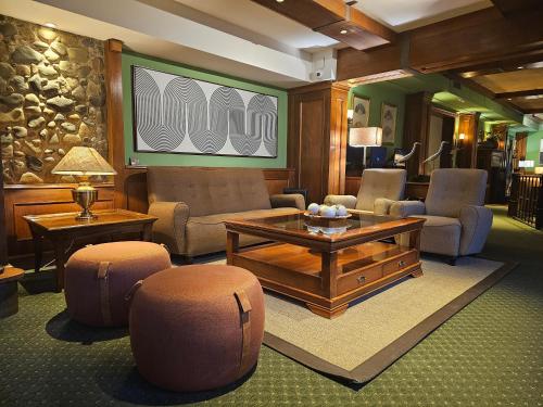 a living room with a coffee table and chairs at Hotel Quijote in El Calafate