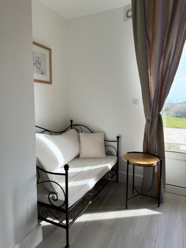 a bedroom with a bed and a chair and a window at Logement entier de charme, gite équestre GERS Flamarens in Flamarens