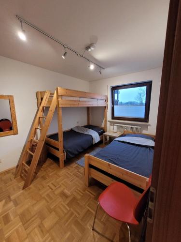 een slaapkamer met 2 bedden en een stapelbed bij Ferienwohnung Hedy in Prien am Chiemsee