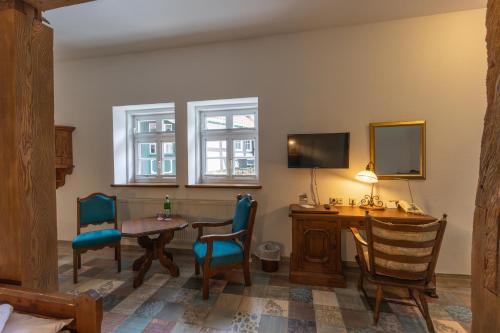 a room with a table and chairs and a desk at Landhotel Der Buchenhof Bad Essen in Bad Essen