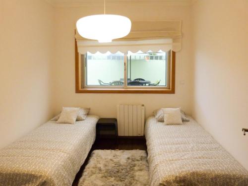 Duas camas num quarto com uma janela em Fonsi House no Porto