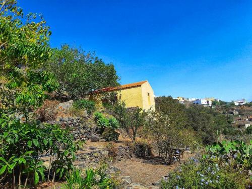 un edificio amarillo en la cima de una colina con árboles en One bedroom bungalow with terrace at Carreteria 9 km away from the beach, en Moya
