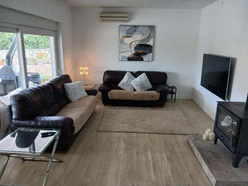 a living room with a couch and a tv at Finca Vista El Montanes in Málaga