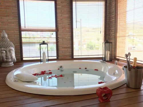 a large white bath tub in a room with windows at 7 bedrooms villa with private pool jacuzzi and wifi at Granada in La Zubia
