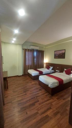 2 camas en una habitación de hotel con suelo de madera en Hotel Harmony Ptv Ltd, en Katmandú