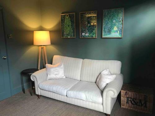 a living room with a white couch and a lamp at Character cottage in Stamford in Stamford