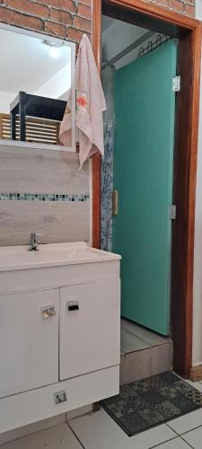 a bathroom with a sink and a mirror and a door at Loft Acolhedor Vista Incrível 2719 in Sao Paulo