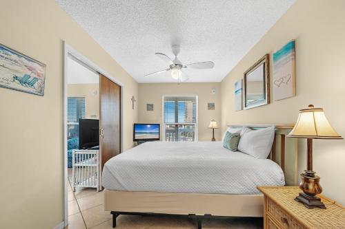 een slaapkamer met een groot bed en een televisie bij The Cove Unit 201A in Gulf Shores