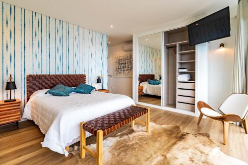 a bedroom with a large bed and a chair at One Sweet World in Calheta