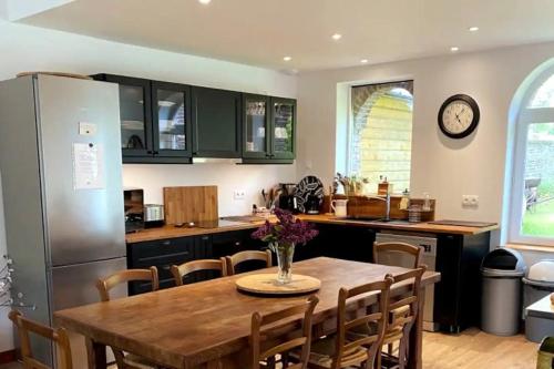une cuisine avec une table en bois et un réfrigérateur dans l'établissement Charmant cottage 8 personnes en Normandie, à Cleuville