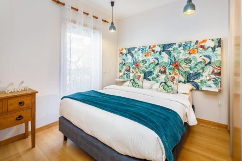 a bedroom with a large bed with a large painting on the wall at Green House - Pool on Rooftop in Olhão