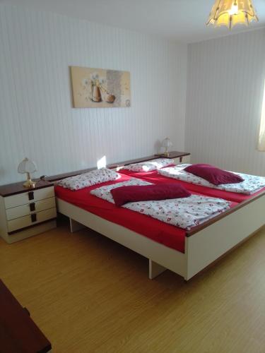 a bedroom with a large bed with red pillows at Ferienhaus Frankenhöhe in Diebach