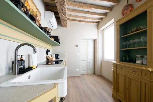 a kitchen with a large white sink and green cabinets at Borgo35 in Parma