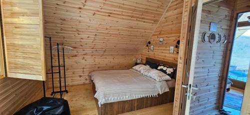 a small room with a bed in a wooden cabin at LIMA in Kutaisi