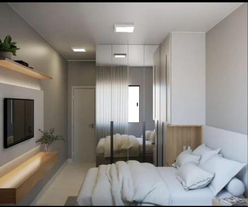 sypialnia z dużym białym łóżkiem i telewizorem w obiekcie Lokehouse w mieście Itajaí