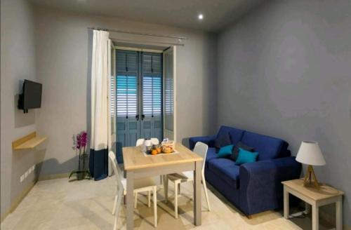 トラーパニにあるZIBIBBO SUITES & ROOMS - Aparthotel in Centro Storico a Trapaniのリビングルーム(青いソファ、テーブル付)