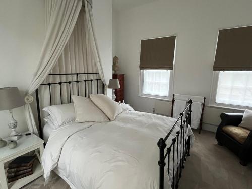 a bedroom with a large bed with white sheets and pillows at The Georgian House in London