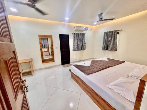 a bedroom with a bed and a mirror in it at Vishranti resort and villa kashid beach in Alībāg