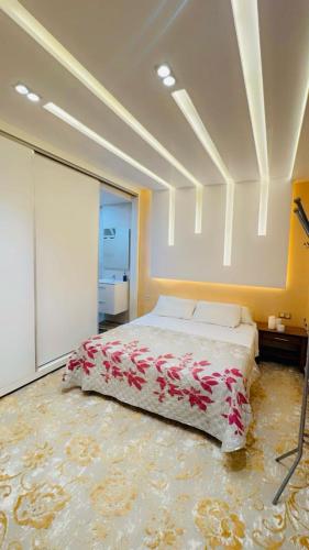 1 dormitorio con 1 cama grande con flores rojas en Luxury, en Tetuán