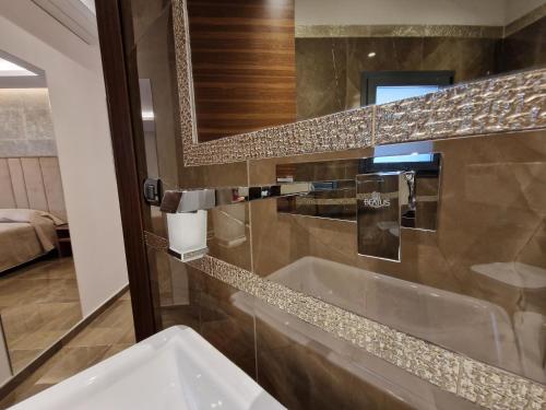 a bathroom with a sink and a mirror at Beatus Suites And Rooms B&B in Canicattì