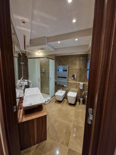a large bathroom with two sinks and a toilet at Beatus Suites And Rooms B&B in Canicattì