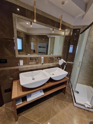 a bathroom with two sinks and a large mirror at Beatus Suites And Rooms B&B in Canicattì