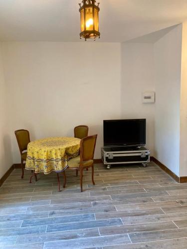 une salle à manger avec une table avec des chaises et une télévision dans l'établissement Charmant studio terrasse 25min Aéroport CDG, à Saint-Brice-sous-Forêt