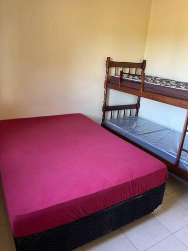 1 dormitorio con 2 literas con sábanas rosas en Casa Verde en Capão da Canoa