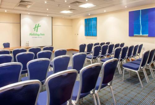 a conference room with blue chairs and a table at Holiday Inn Rochester-Chatham by IHG in Chatham