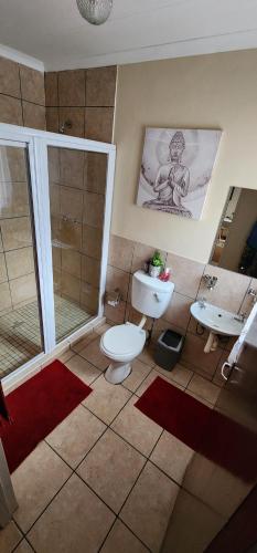 a bathroom with a toilet and a sink at Cottage @ Ezulwini in Lobamba