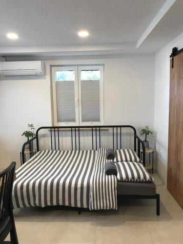 a bedroom with a bed with a striped blanket at Bella Vista apartment 2 in Izola