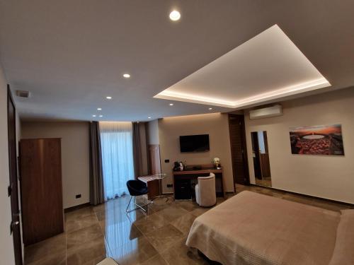 a hotel room with a bed and a desk at Beatus Suites And Rooms B&B in Canicattì