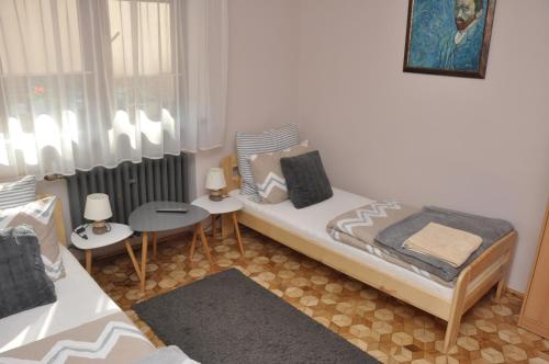 a bedroom with a bed and two tables and chairs at Apartament Pod Świerkami in Olecko