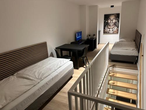1 Schlafzimmer mit 2 Betten und einem Schreibtisch mit einem Tisch in der Unterkunft Schokoladenmuseum - Top Lage - Souterrain Apartment in Köln