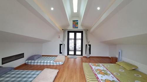 een slaapkamer op zolder met 2 bedden en een raam bij Vimala Hills Villa 2BR atau 3BR in Megamendung