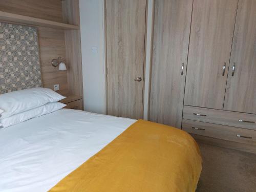 a bedroom with a bed and wooden cabinets at Alphi 4 in Bude